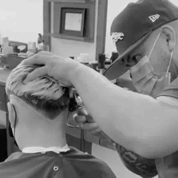 Barber clipping hair into a design